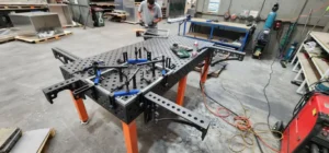 Welding table clamps in use in a fabrication workshop